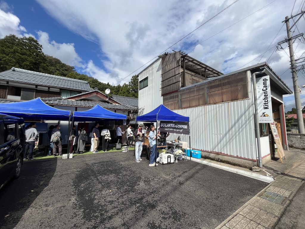 KitchenCamp OUTLET店舗前に並ぶ青いテントと、オープン日に集まった来場者
