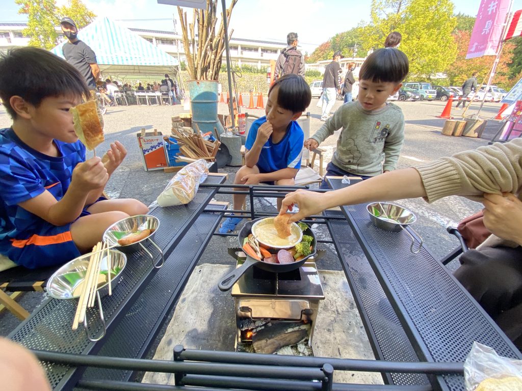 火を囲んで味噌チーズフォンデュを頬張る子供たち　画像